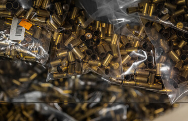 Empty brass pistol cartridges, ammo in bulk on display at a gun shop, ammunition shortage in California - obrazy, fototapety, plakaty