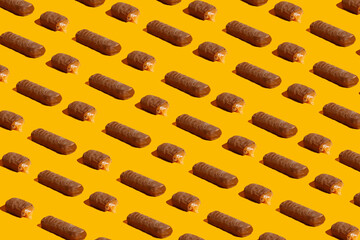 Chocolate bar with caramel on a yellow background. Pattern
