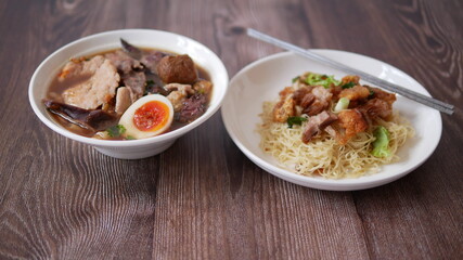Set of Chinese noodle, a bowl of paste of rice flour over with pork egg and a plate of egg noodle with crispy pork