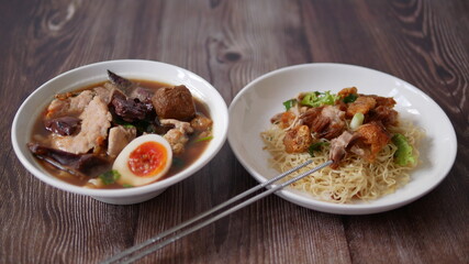 Set of Chinese noodle, a bowl of paste of rice flour over with pork egg and a plate of egg noodle with crispy pork