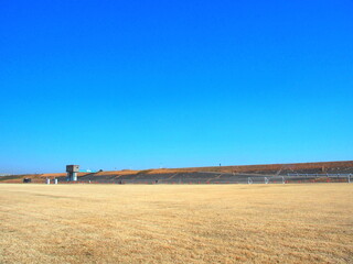 枯れ芝のサッカー場のある冬の江戸川河川敷風景