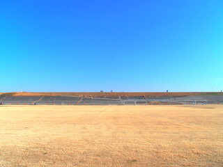 枯れ芝のサッカー場のある冬の江戸川河川敷風景