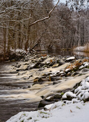 River rapids in a snowy winter forest. Picture Ronne River, Scania county, Sweden
