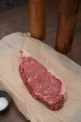 raw new york steak on walnut wood background with copy space