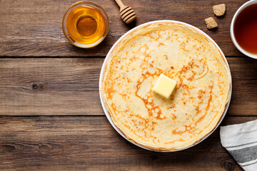 Flat lay composition with fresh thin pancakes or crepes on  wooden table . Space for text