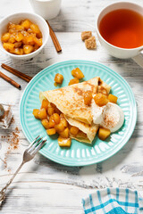 Crepes, thin pancakes with caramelized apple filling and cream fresh. Healthy breakfast in sunny morning .