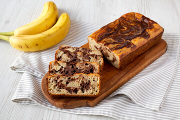 Homemade Chocolate Banana Bread on a rustic wooden board, side view.