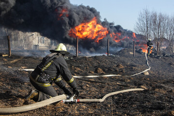 Firefighters extinguish a fire. Lifeguards with fire hoses in smoke and fire