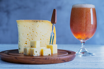 Piece of ammergauer beer cheese on a light wooden table