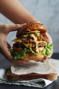 Close-up Of Hand Holding Burger
