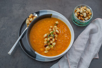 Pumpkin soup and organic pumpkins on wooden table