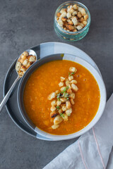 Pumpkin soup and organic pumpkins on wooden table