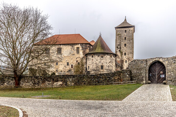 Fototapeta na wymiar Massive and well fortified medieval Water Castle of Svihov is situated in the Pilsen Region, Czech Republic, Europe. There are water canal around the stone castle. Winter view.