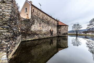 Fototapeta premium Massive and well fortified medieval Water Castle of Svihov is situated in the Pilsen Region, Czech Republic, Europe. There are water canal around the stone castle. Winter view.