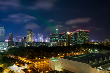 Fototapeta na wymiar The beams of laser pierce the night sky above Kowloon. The show starts daily at 8pm when the lasers from the tallest buildings in Hong Kong shine into the night.