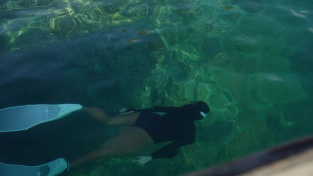 Confidence Asian woman in swimsuit and diving flipper swimming with snorkeling in the sea enjoy with beautiful nature underwater. Female love outdoor activities and water sport in holiday vacation.