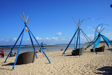 Place for beach holidays with umbrellas, chaise longue, and people in Nusa Dua Beach, Bali island, Indonesia