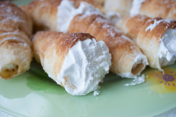 photo of traditional Italian straws with egg cream and powdered sugar, Italian dessert on a beige background, delicious Italian connoncini