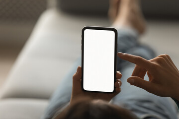Crop close up back view of woman hold use modern smartphone gadget texting or messaging online. Female user browse internet on cellphone device. Distant communication, mockup white screen concept.