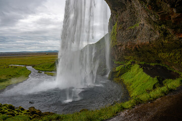 seljalandsfoss waterfall in iceland on cloudy day.
