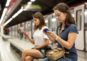 Young woman with phone on subway station. High quality photo