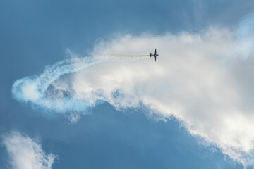 The aerobatic plane with smoke track in the sky