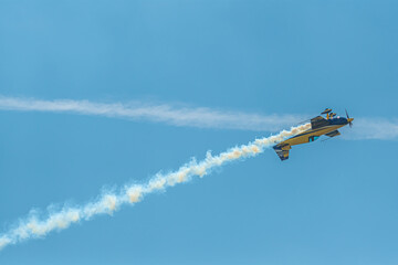 The aerobatic plane with smoke track in the sky - obrazy, fototapety, plakaty