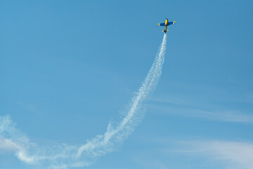 The aerobatic plane with smoke track in the sky