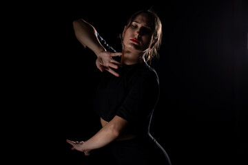 Fototapeta premium Young Woman in a black dress dancing, Young professional dancer practicing in a studio , dancer