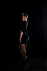 Fototapeta na wymiar Young Woman in a black dress dancing, Young professional dancer practicing in a studio , dancer