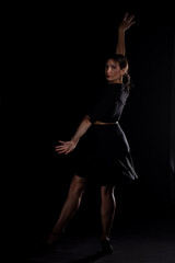 Obraz premium Young Woman in a black dress dancing, Young professional dancer practicing in a studio , dancer
