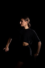 Fototapeta na wymiar Young Woman in a black dress dancing, Young professional dancer practicing in a studio , dancer