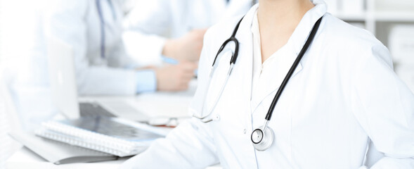 Group of unknown doctors discussing problems to stop coronavirus pandemic while sitting at meeting in clinic, close-up . Medicine concept