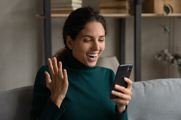 Happy millennial woman look at smartphone screen shocked by unexpected good message online. Smiling young Caucasian female stunned surprised by unbelieving news or text, win lottery on cell on web.