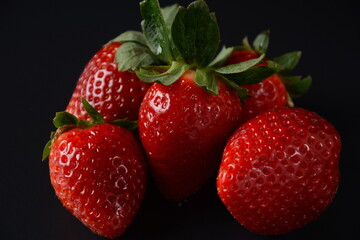 Fototapeta na wymiar Strawberry fresh organic fruit. Strawberries with leaves. Isolated on a black background.
