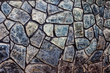 Covering the wall of the house with flat stone close-up in summer