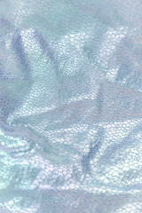 Creased textile texture, background template. Shine  light blue fabric drapery. Sheene sharkskin fabrics for fashion dress.
