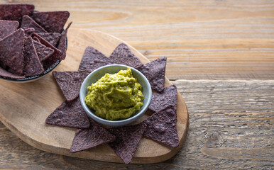 Blue corn crisps with guacamole on the side.Blue corn tortilla chips with homemade guacamole on the side.
