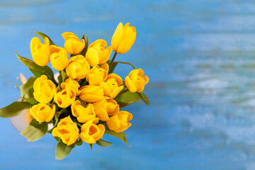 Beautiful bouquet of yellow tulips on a blue background