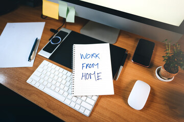 Work form home on virus corona pandemic WFH text on workplace table with computer.