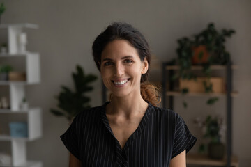Profile picture of smiling young Caucasian 20s woman stand pose in own renovated apartment or...