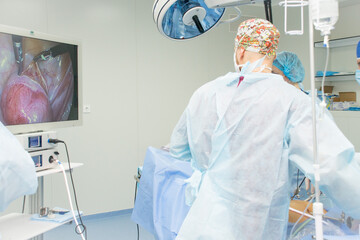 surgeon and assistants perform an operation on the human body. Doctor sutures