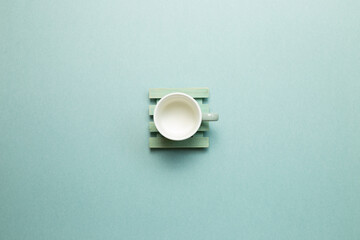Empty mug cup on mint green background. top view, copy space