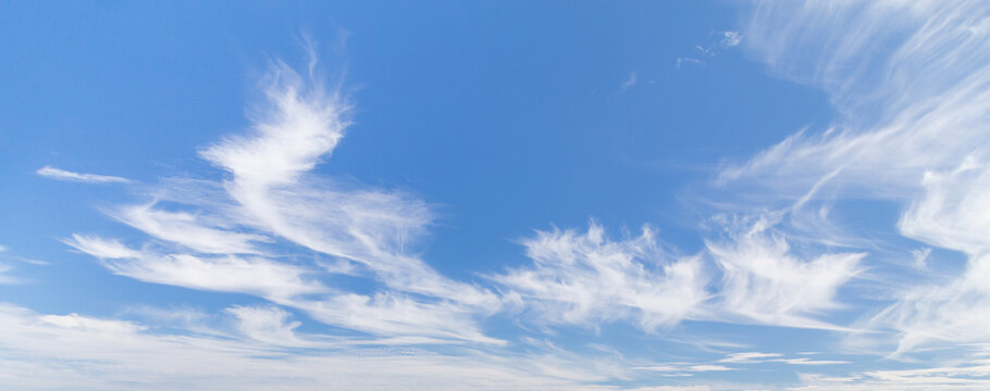 Blue sky panoramic background with beautiful wispy clouds.