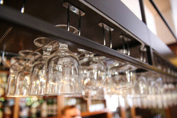 Fototapeta na wymiar Many clean glasses on metal rack in restaurant