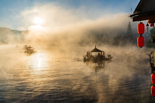 Lake view misty morning of reservoir around with soft mist with yellow sun light in the sky background, sunrise at Ban Rak Thai, Mae Hong Son, northern of Thailand. ,bluerred image