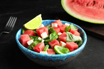 Delicious salad with watermelon served on black table