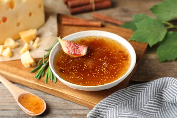 Delicious fig jam with fresh fruit on wooden table, closeup