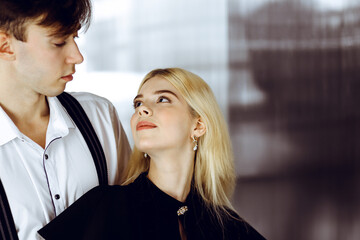 Young couple of businessman and woman are standing in a modern office. Portrait of successful business people