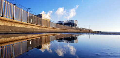 Heysham nuclear power station reflected in a puddle.